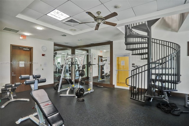 gym with ceiling fan and a drop ceiling