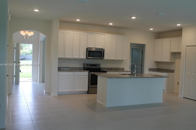 kitchen with white cabinets, a center island with sink, stainless steel appliances, and sink