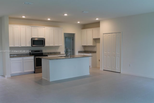 kitchen with white cabinets, a center island with sink, stainless steel appliances, and sink