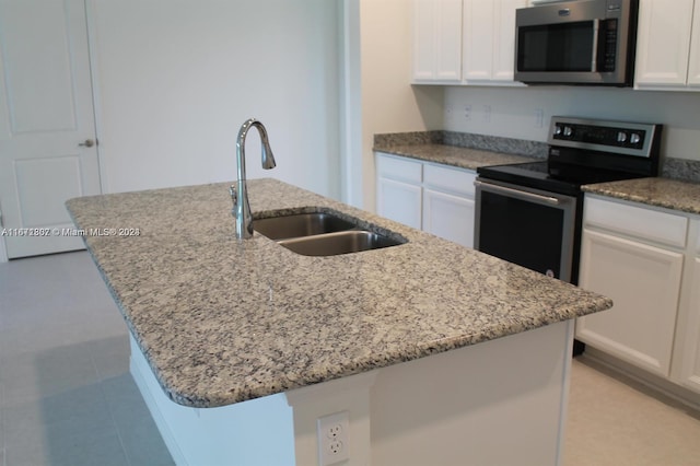 kitchen featuring an island with sink, appliances with stainless steel finishes, sink, and white cabinetry