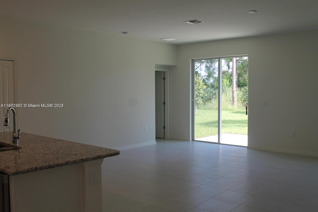 empty room featuring light tile patterned flooring and sink