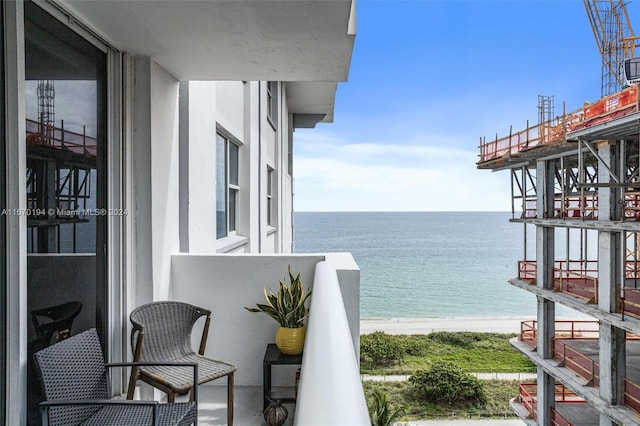 balcony with a water view and a beach view