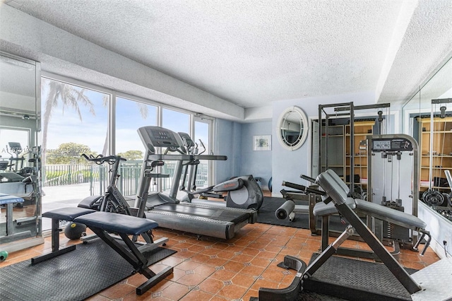 exercise room featuring dark tile patterned flooring and a textured ceiling