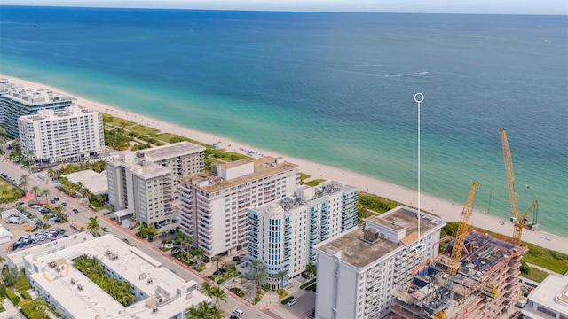 drone / aerial view with a water view and a beach view