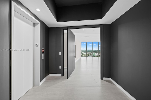 hallway with elevator and expansive windows