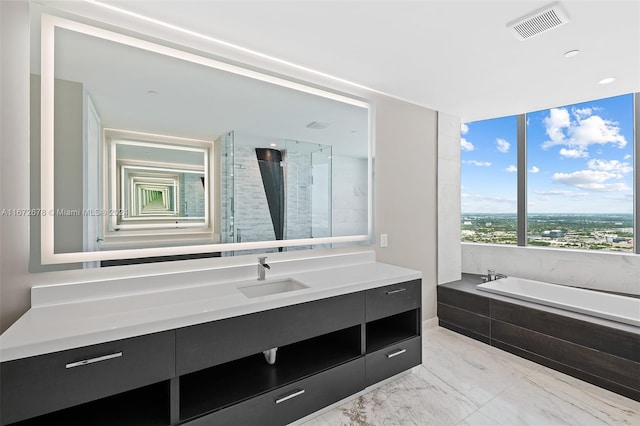 bathroom featuring shower with separate bathtub and vanity