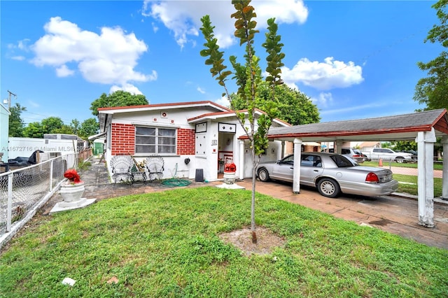 view of front of home with a carport and a front yard