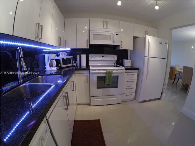 kitchen featuring white appliances, sink, backsplash, light tile patterned floors, and white cabinetry