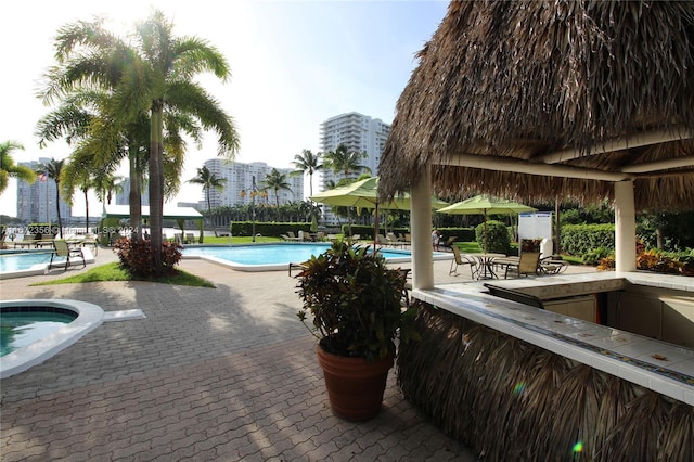 view of swimming pool with a jacuzzi and a patio area