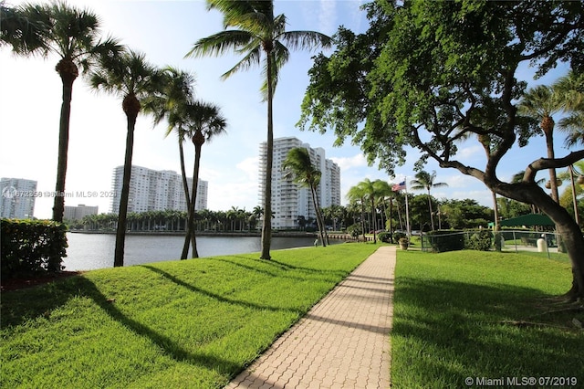 surrounding community featuring a water view and a lawn