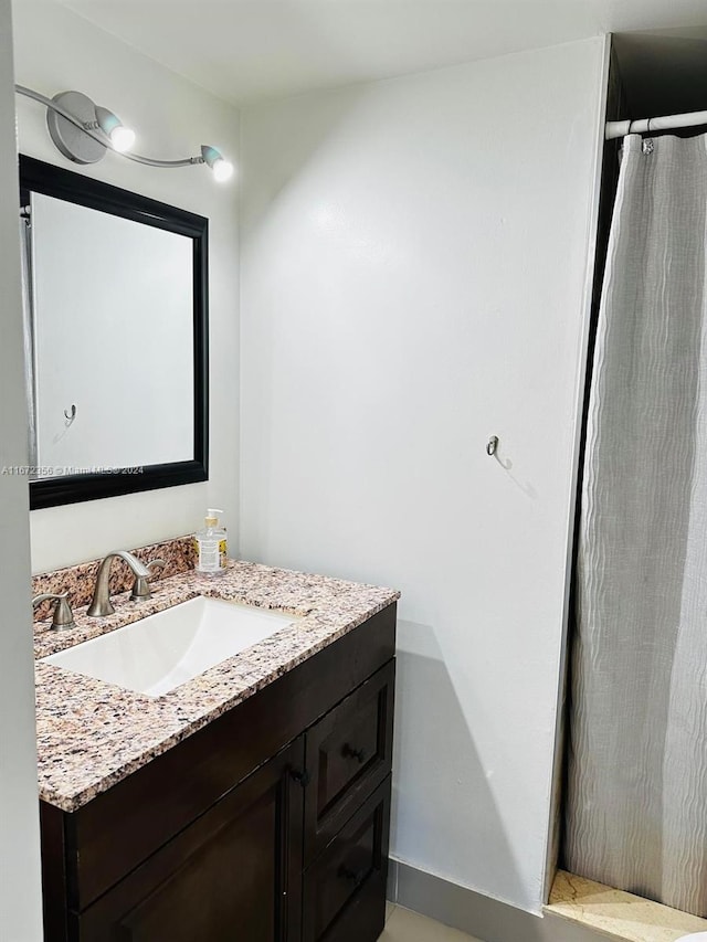 bathroom featuring walk in shower and vanity