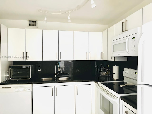 kitchen with white appliances, backsplash, white cabinets, and sink