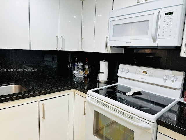 kitchen featuring white appliances, backsplash, white cabinets, and sink