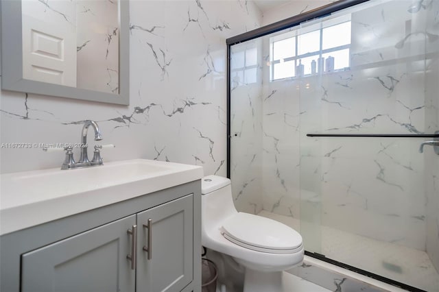 bathroom with vanity, a shower with shower door, and toilet