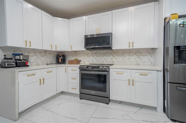 kitchen with tasteful backsplash, white cabinets, and appliances with stainless steel finishes