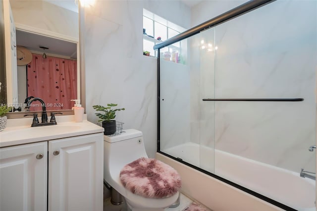 bathroom featuring enclosed tub / shower combo and vanity