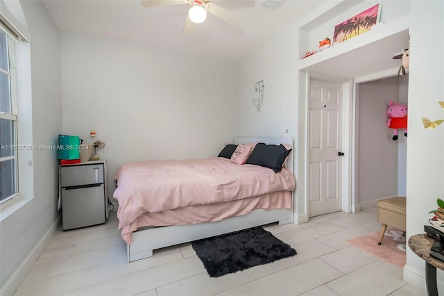 bedroom featuring stainless steel fridge and ceiling fan