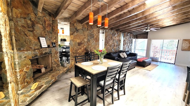 dining room with wooden ceiling, ceiling fan, a fireplace, light hardwood / wood-style flooring, and lofted ceiling with beams