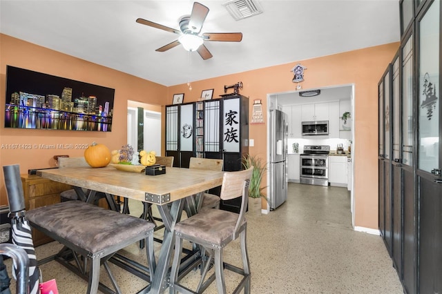 dining space with a ceiling fan, light speckled floor, visible vents, and baseboards