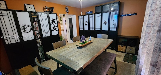 dining space featuring speckled floor