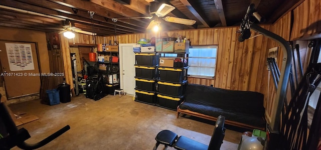 interior space with wooden walls and a ceiling fan