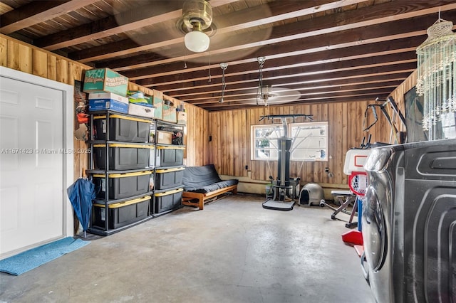 basement featuring a garage, washer / dryer, and wood walls