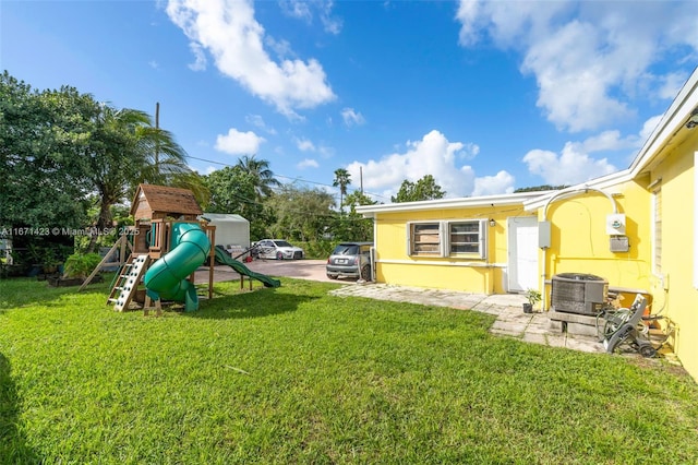 view of yard with a playground and central AC