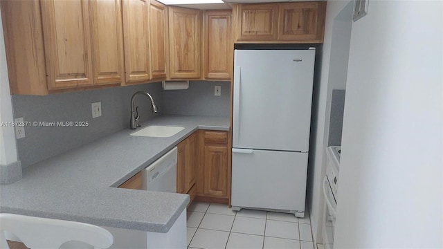 kitchen featuring light tile patterned floors, white appliances, tasteful backsplash, and sink