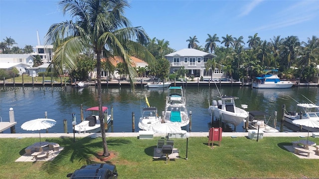 view of dock featuring a lawn and a water view