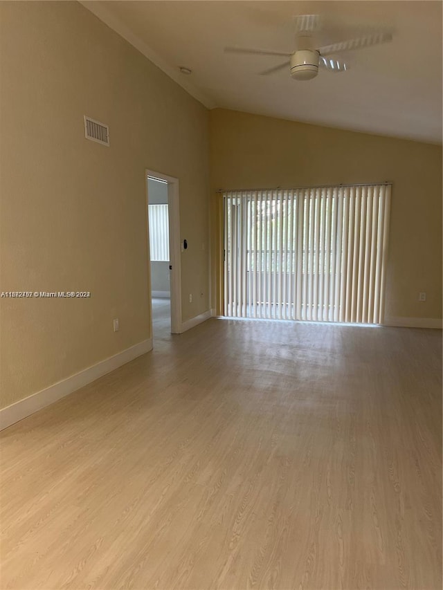 spare room featuring ceiling fan, light wood-type flooring, and vaulted ceiling