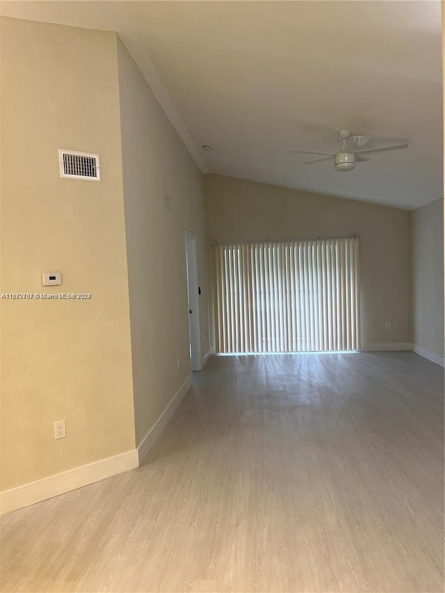 unfurnished room featuring lofted ceiling, light hardwood / wood-style floors, and ceiling fan