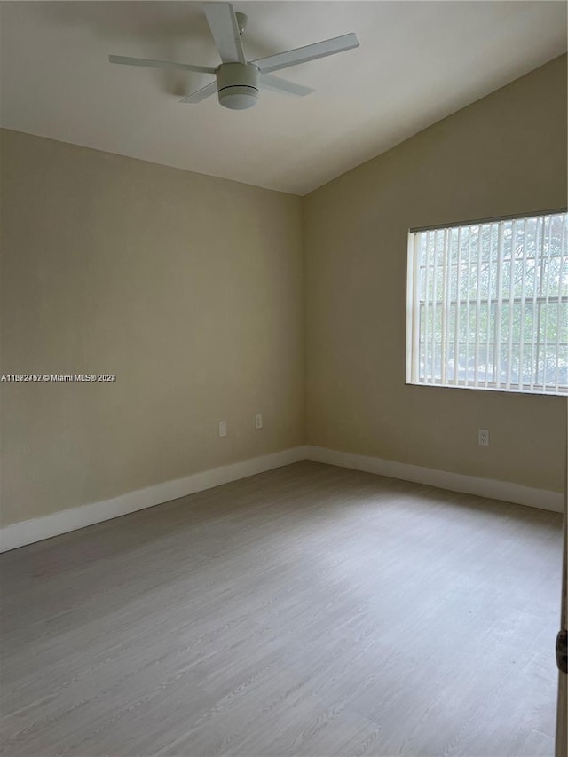 empty room with vaulted ceiling, ceiling fan, and light hardwood / wood-style flooring