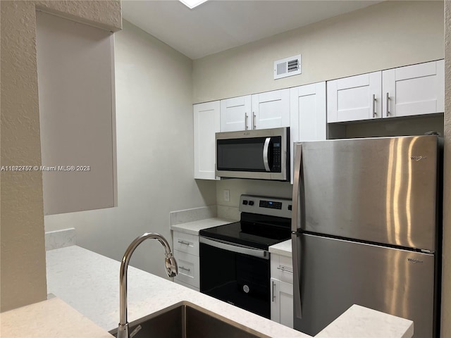 kitchen featuring white cabinetry and appliances with stainless steel finishes