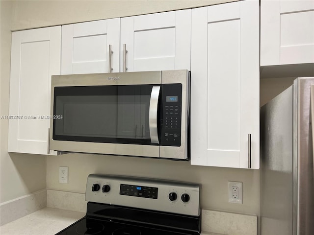 interior details featuring white cabinets and appliances with stainless steel finishes