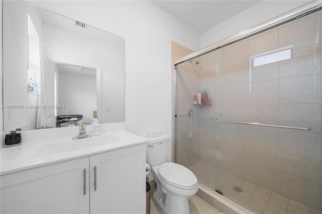 bathroom with vanity, toilet, and a shower with door