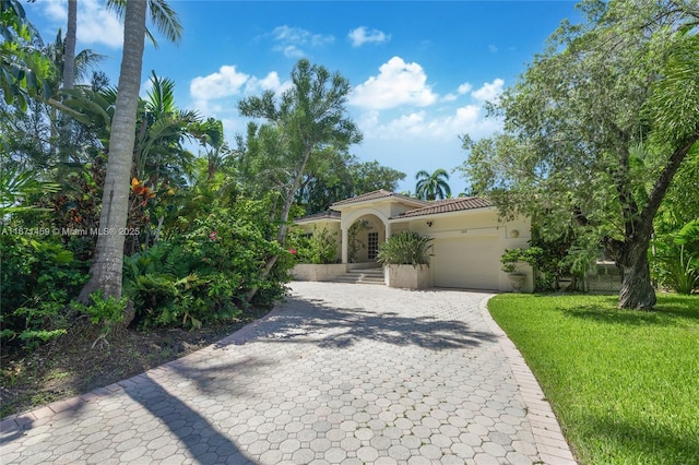 mediterranean / spanish-style house with a garage and a front yard