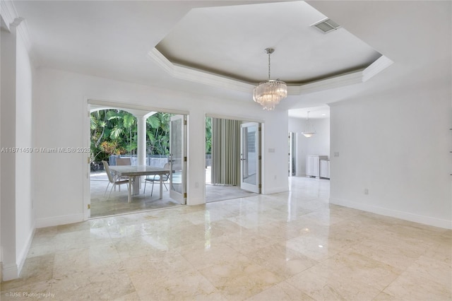 unfurnished dining area with crown molding, a tray ceiling, and a chandelier