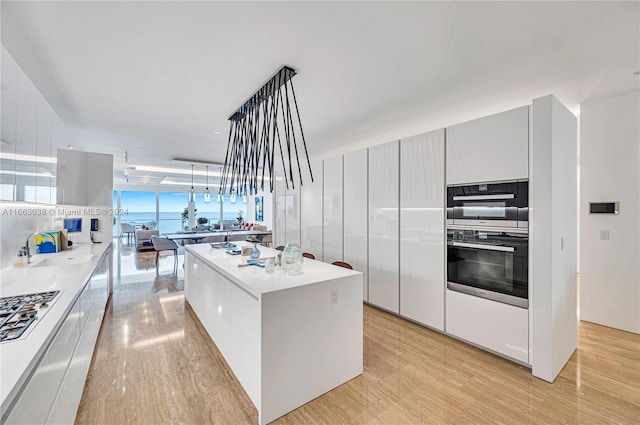 kitchen with pendant lighting, light hardwood / wood-style flooring, white cabinetry, and a center island