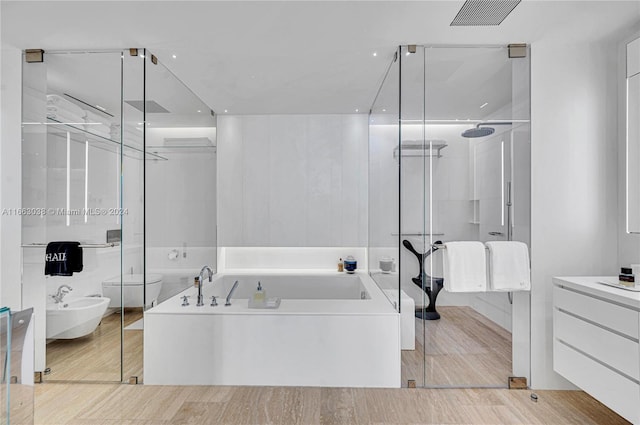 bathroom featuring a bidet, hardwood / wood-style flooring, vanity, and separate shower and tub