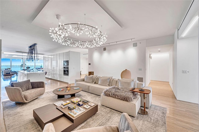 living room with a chandelier and light hardwood / wood-style floors