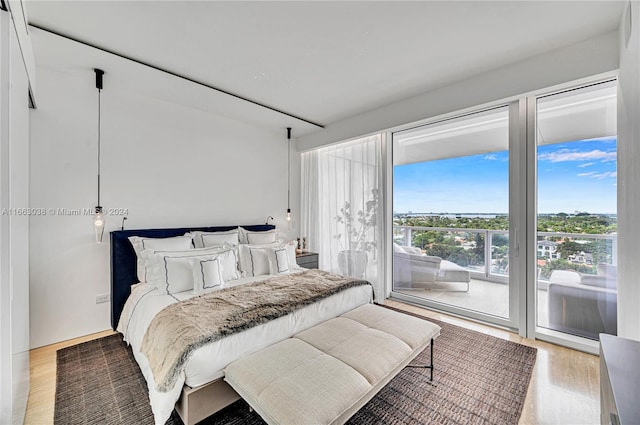 bedroom with wood-type flooring and access to outside