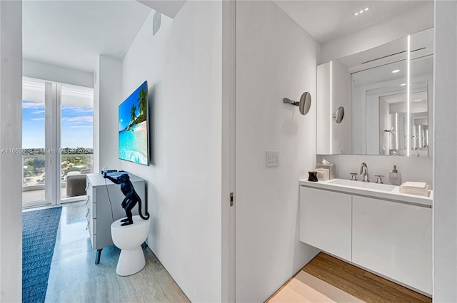 bathroom featuring wood-type flooring, vanity, and toilet