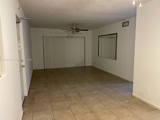 unfurnished room featuring light tile patterned flooring, a textured ceiling, and ceiling fan