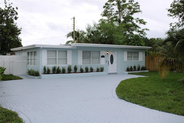 single story home featuring a front lawn