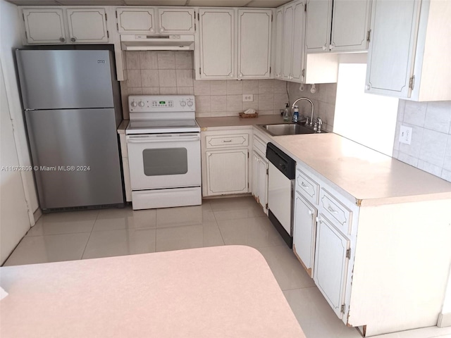 kitchen with decorative backsplash, light tile patterned flooring, white cabinetry, white appliances, and sink