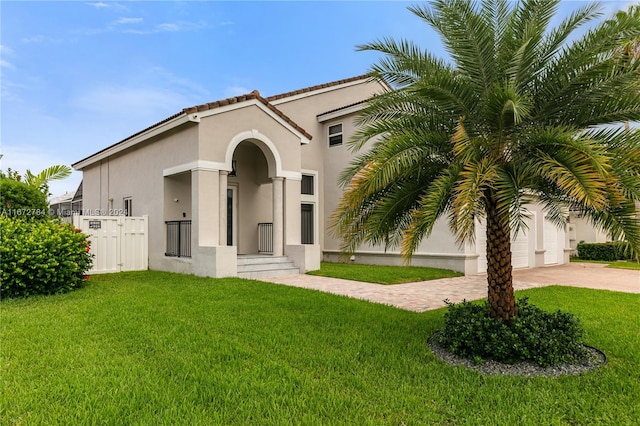 mediterranean / spanish-style house with a garage and a front yard