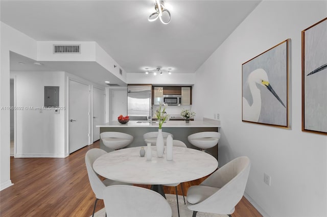 dining area featuring baseboards, visible vents, and wood finished floors