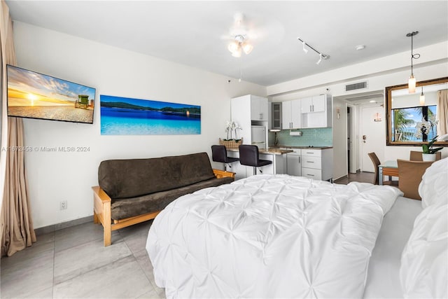 bedroom featuring white refrigerator and rail lighting