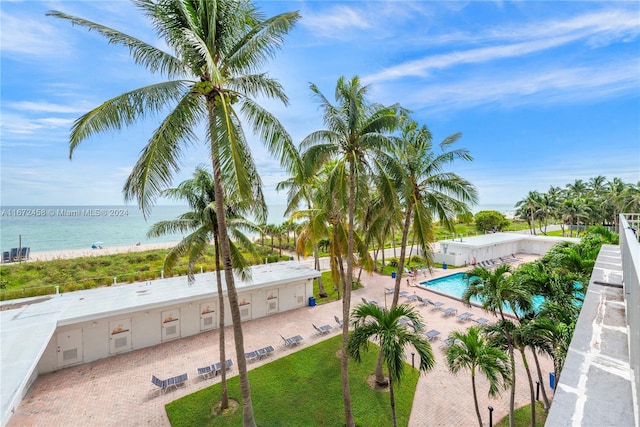 view of pool featuring a water view and a patio