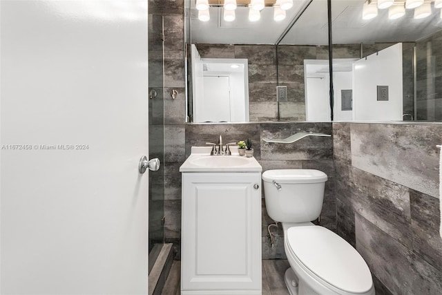 bathroom featuring vanity, tile walls, and toilet